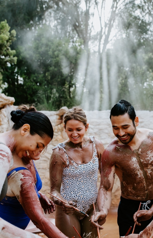 Eine Gruppe von Freunden nimmt an einer Wellnessbehandlung mit Ton in den Peninsula Hot Springs teil © Peninsula Hot Springs 