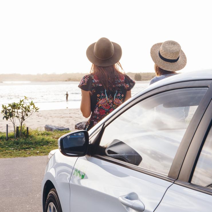 Two girls sat on front of Jucy car looking over the beach in Noosa © Jucy Two girls sat on front of Jucy car looking over the beach in Noosa © Jucy
