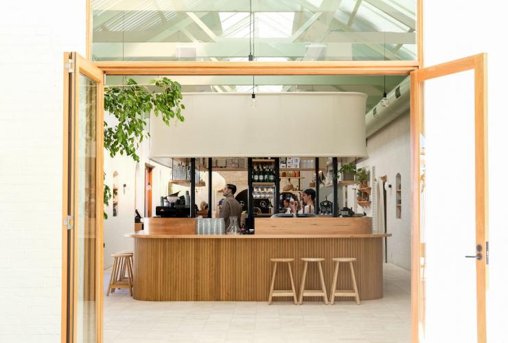 A light-filled cafe with baristas working behind a wooden counter at Bloom, Adelaide, South Australia © Bloom A light-filled cafe with baristas working behind a wooden counter at Bloom, Adelaide, South Australia © Bloom