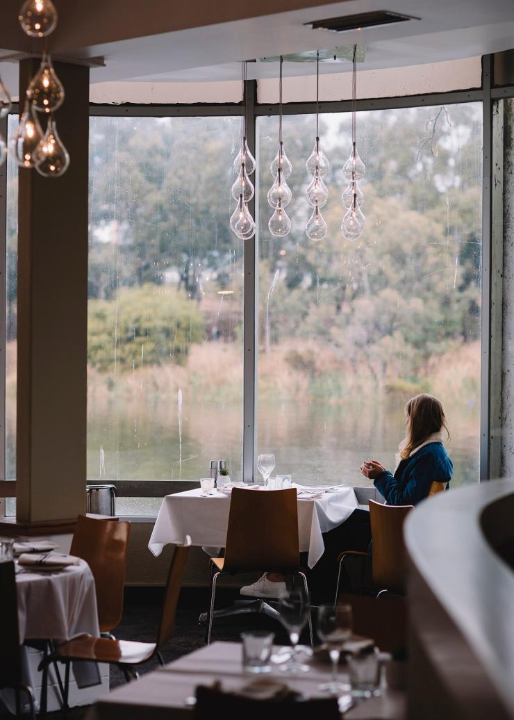A person sitting in a restaurant beside a floor to ceiling window admiring the view over a tranquil waterway at the River Café, North Adelaide, South Australia © Tourism Australia A person sitting in a restaurant beside a floor to ceiling window admiring the view over a tranquil waterway at the River Café, North Adelaide, South Australia © Tourism Australia