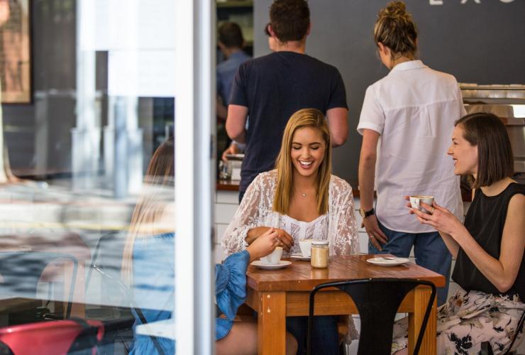 A group of friends smiling and talking over coffee in a bustling cafe at Exchange Specialty Coffee, Adelaide, South Australia © South Australian Tourism Commission A group of friends smiling and talking over coffee in a bustling cafe at Exchange Specialty Coffee, Adelaide, South Australia © South Australian Tourism Commission