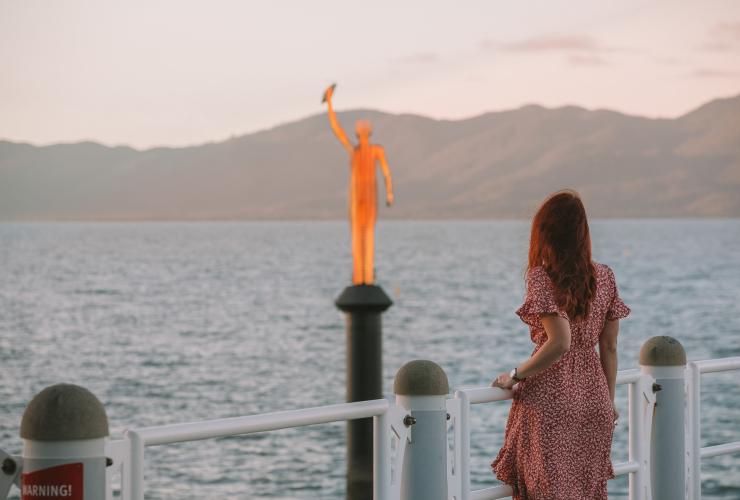 Woman admires the Museum of Underwater Art’s Ocean Siren sculpture from the Strand Jetty in Townsville © Tourism and Events Queensland