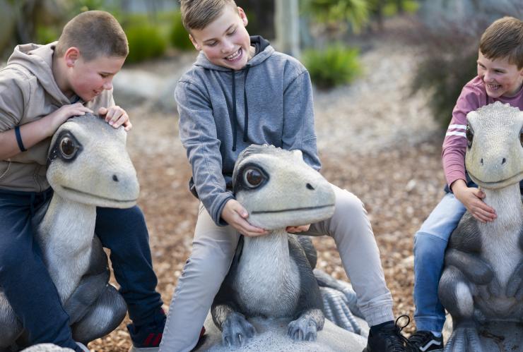 Child sitting on a dinosaur at the National Dinosaur Museum, ACT © Tourism Australia