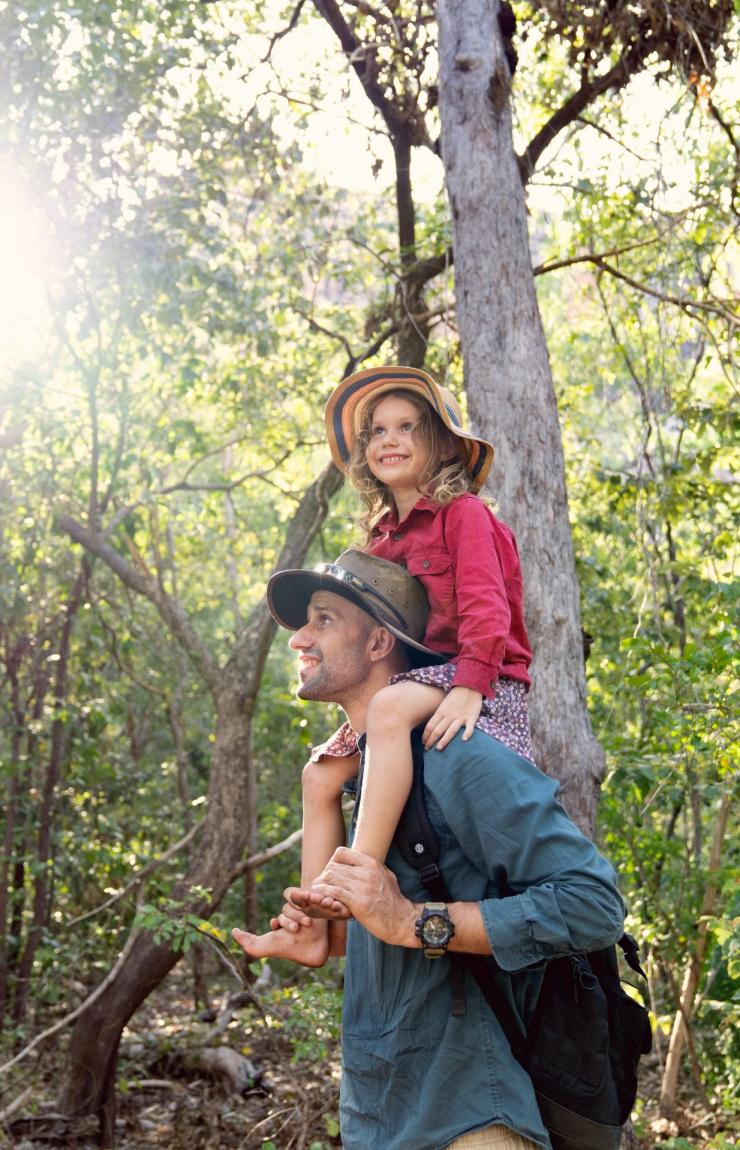A child sits on her father's shoulders in the forest on a tour with Offroad Dreaming, Kakadu National Park, Northern Territory © Tourism Australia
