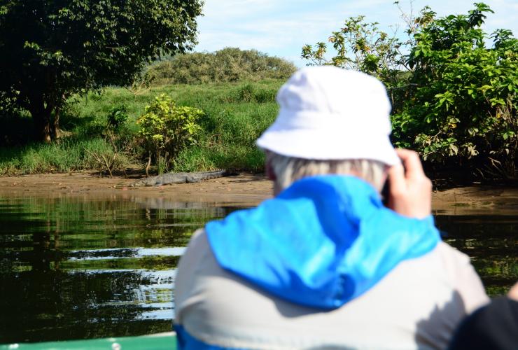 Photographer takes photos of a saltwater crocodile on a river bank © FNQ Nature Tours