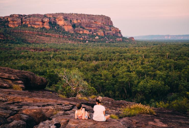 Two people sat on a rock looking at Burrungkuy (Nourlangie) Rock © Tourism NT/Jewels Lynch