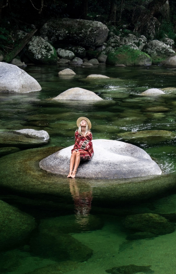 Woman sitting on a boulder in Mossman Gorge in the Daintree National Park © Luxury Lodges of Australia