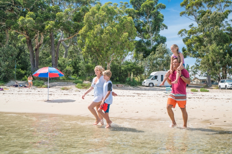 Family strolling alongside Tilligerry Creek © Destination NSW