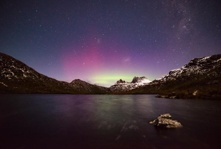 Man with head torch looks up at the night sky filled with bright stars over the dark sky park in the Warrumbungles © Destination NSW