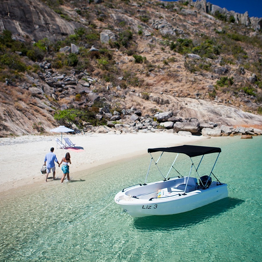 Couple on private beach with boat on Lizard Island © Lizard Island