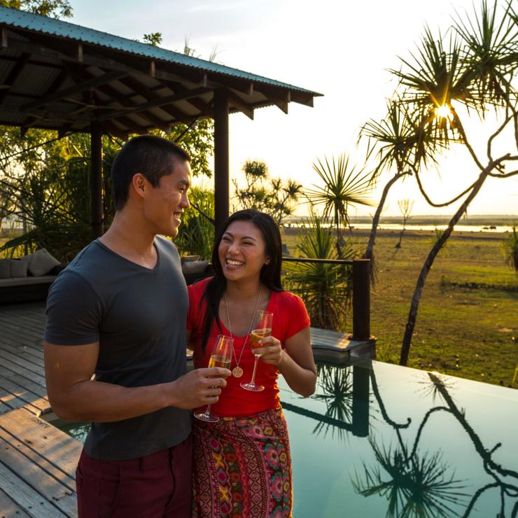 Visitors drinking champagne next to the infinity pool at Bamurru Plains © Tourism NT/Peter Eve