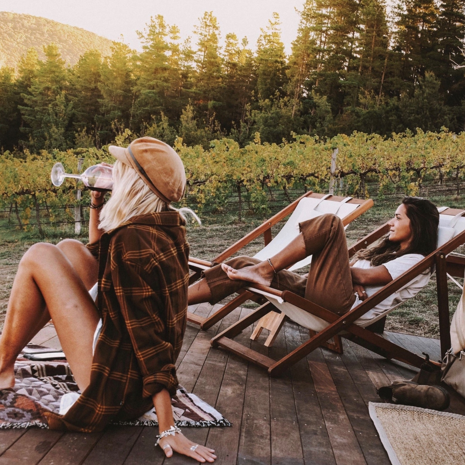 Femmes buvant du vin à l'extérieur d'une tente de glamping de Naked Cubby Co près de Canberra © Naked Cubby Co/Shan Bawden