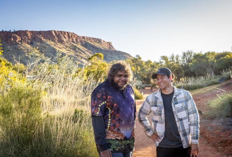 Homme neurodivergent debout avec un guide au Alice Springs Desert Park, Alice Springs, Territoire du Nord © Tourism NT/Helen Orr