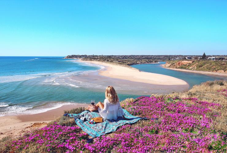 Une jeune femme apprécie son pique-nique au milieu des fleurs sauvages sur la Fleurieu Peninsula © Elise Cook