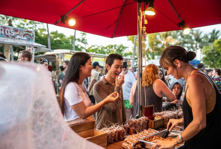 Pasangan mencicipi makanan dari sebuah kios di Mindil Beach Sunset Market, Darwin, Northern Territory © Tourism NT/Helen Orr