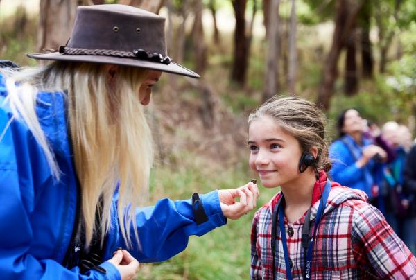Seorang anak yang mengenakan headset bersama pemandu tur Wildlife Wonders, Great Ocean Road, Victoria © Tourism Australia/Wildlife Wonders