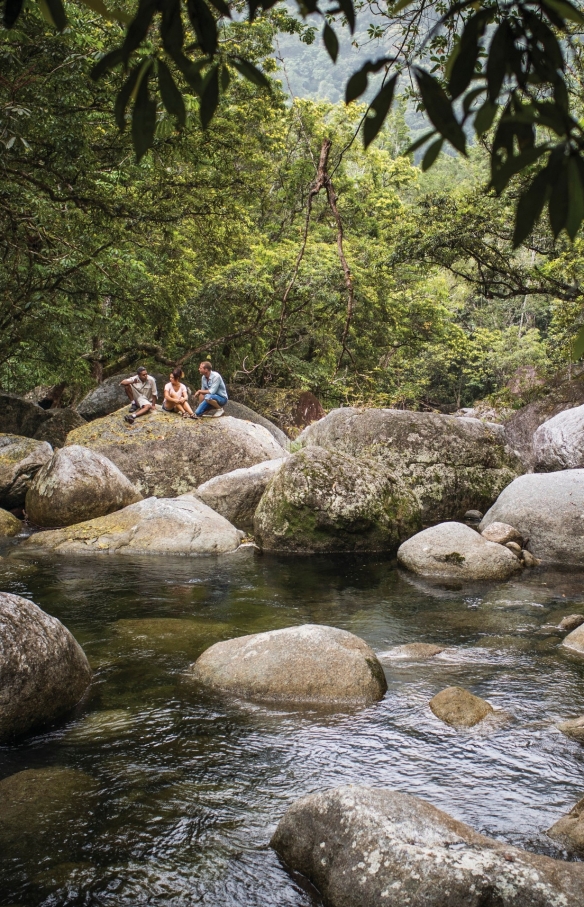 Wanita duduk di batu di dekat kolam bebatuan di Mossman Gorge © Tourism and Events Queensland