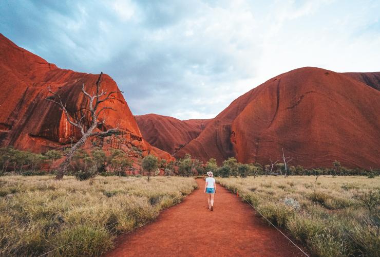 Seorang pengunjung berjalan mengelilingi dasar Uluru, NT © Tourism NT/Jackson Groves Seorang pengunjung berjalan mengelilingi dasar Uluru, NT © Tourism NT/Jackson Groves