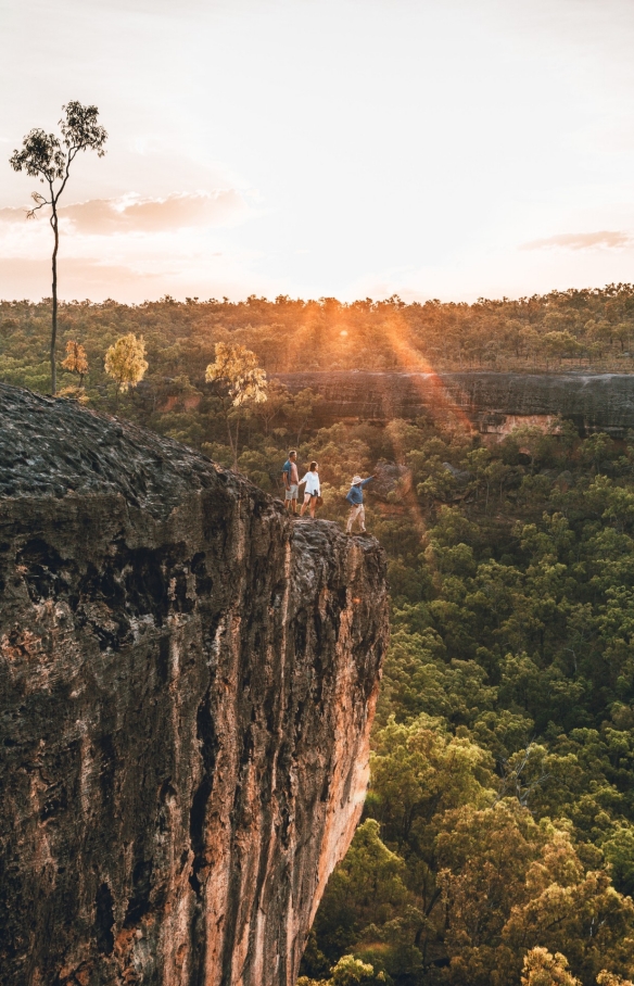 Una guida aborigena e due turisti su un affioramento roccioso che ammirano il verde bushland durante un tour con Jarramali Rock Art Tours, Tropical North Queensland, Queensland © Tourism Tropical North Queensland 