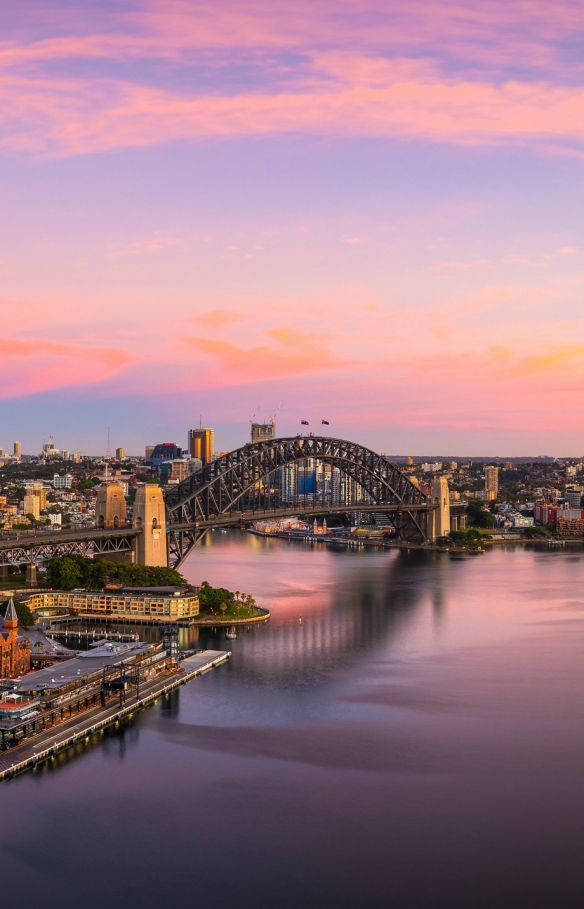 Vista aerea del Sydney Harbour che riflette le tinte blu, rosa e oro del tramonto a Sydney, New South Wales © Destination NSW