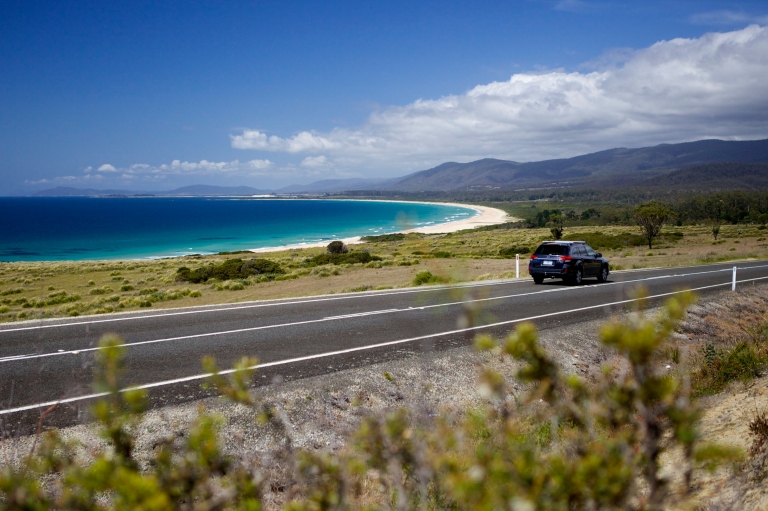 ラグーンズ・ビーチ保護区の海沿いの道路を走る車 © Pete Harmsen/Tourism Tasmania