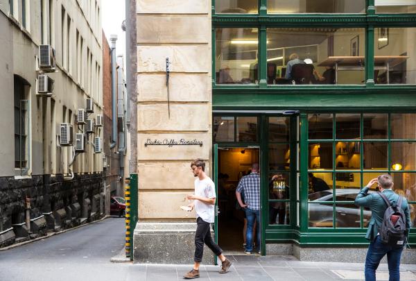 メルボルンのデュークス・コーヒー・ロースターでコーヒーを持ち帰る男性 © Visit Victoria