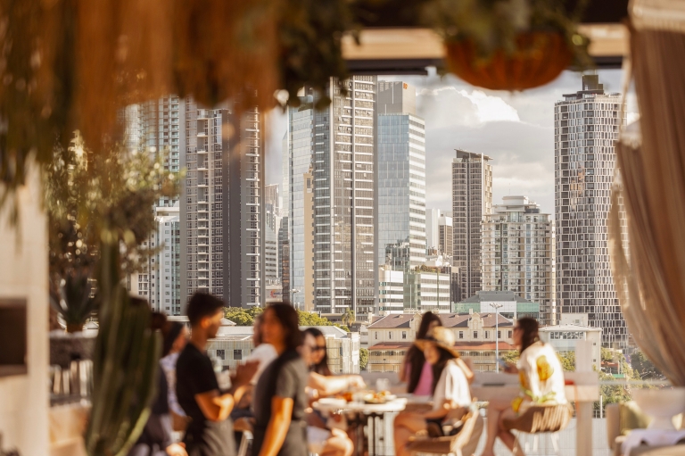 Những người ngồi vào bàn trên quầy bar trên tầng thượng nhìn ra đường chân trời của thành phố, Maya, Brisbane, Queensland © Cơ quan Phát triển Kinh tế Brisbane Những người ngồi vào bàn trên quầy bar trên tầng thượng nhìn ra đường chân trời của thành phố, Maya, Brisbane, Queensland © Cơ quan Phát triển Kinh tế Brisbane