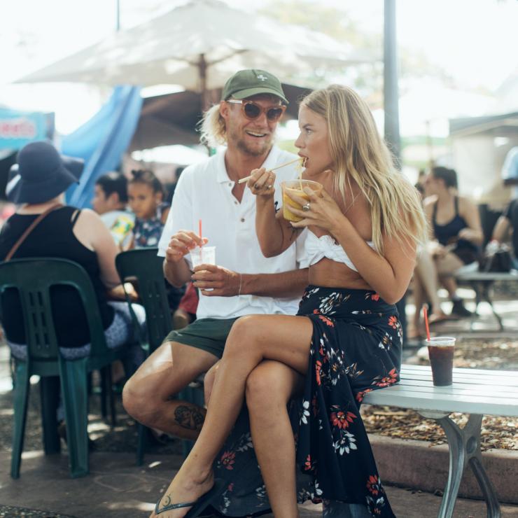 Một cặp vợ chồng ăn thức ăn đường phố tại Chợ Parap Village, Lãnh thổ Bắc Darwin, ngoài trời vào một ngày nắng. © Du lịch Lãnh thổ Bắc Một cặp vợ chồng ăn thức ăn đường phố tại Chợ Parap Village, Lãnh thổ Bắc Darwin, ngoài trời vào một ngày nắng. © Du lịch Lãnh thổ Bắc