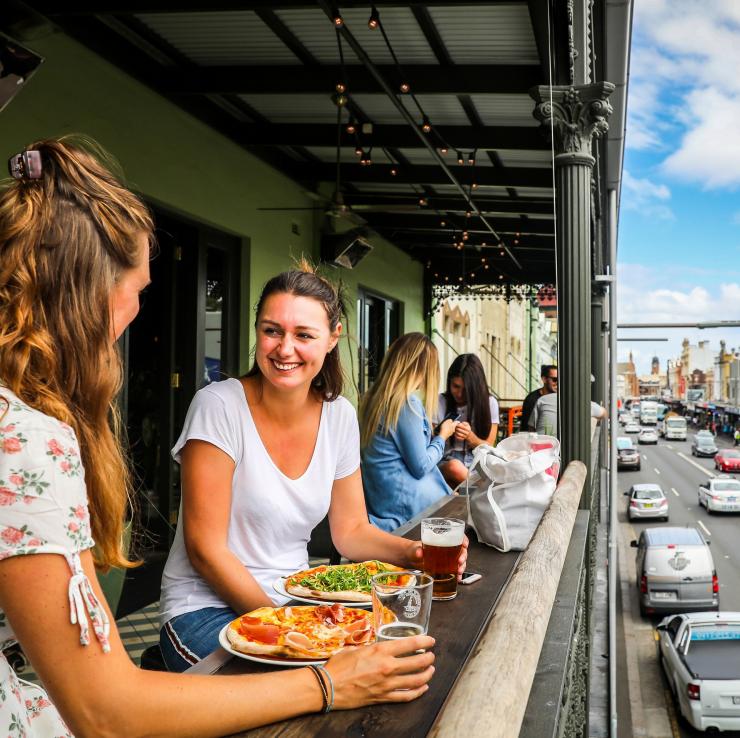 Bạn bè thưởng thức pizza và đồ uống trên ban công của Newtown Hotel © City of Sydney / Katherine Griffiths Bạn bè thưởng thức pizza và đồ uống trên ban công của Newtown Hotel © City of Sydney / Katherine Griffiths
