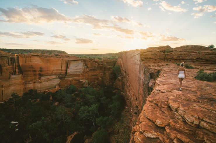  一名女子於日出時在帝王谷（Kings Canyon）頂端漫步©北領地旅遊局/Mitchell Cox（2017年）