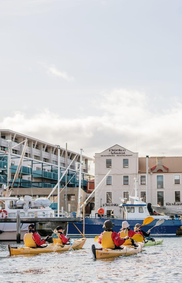 一群Roaring 40s Kayaking體驗的參加者坐在塔斯曼尼亞荷伯特一個碼頭旁黃色的獨木舟中©澳洲旅遊局