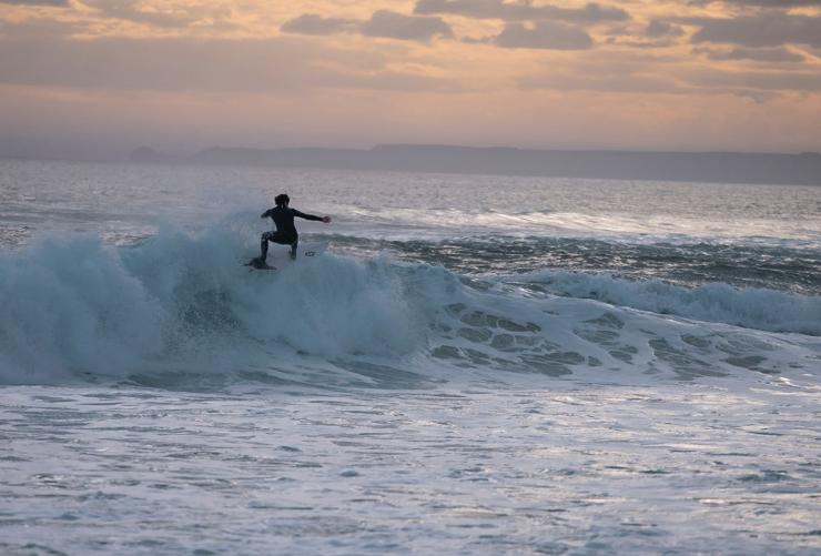 A surfer on the barrel of a wave at sunset at Cape Woolamai, Phillip Island, Victoria © Tourism Australia