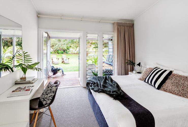 Interior of accommodation with windows looking out toward grass and trees at Pinetrees Lodge, Great Walks of Australia, Seven Peaks Walk, Lord Howe Island, New South Wales © Great Walks of Australia/Elizabeth Allnutt Photography