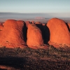 A large red rock monolith rising from the flat outback landscape at Uluru, Uluru-Kata Tjuta National Park, Northern Territory © Tourism Australia