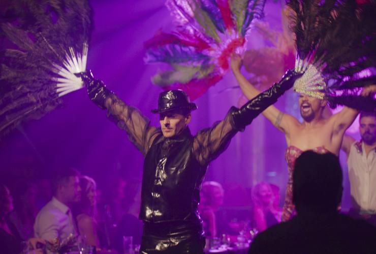 Dancers performing on stage with arms outstretched holding fans beneath purple stage lights during Open Season Music Series, Fortitude Valley, Brisbane, Queensland © Tourism and Events Queensland
