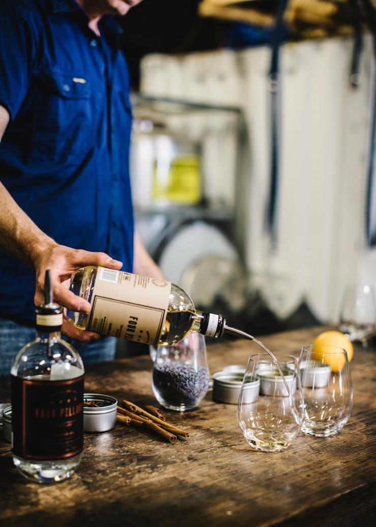 Tour guide pouring gin into a glass for tasting at Four Pillars Gin Distillery, Yarra Valley, Victoria © Tourism Australia