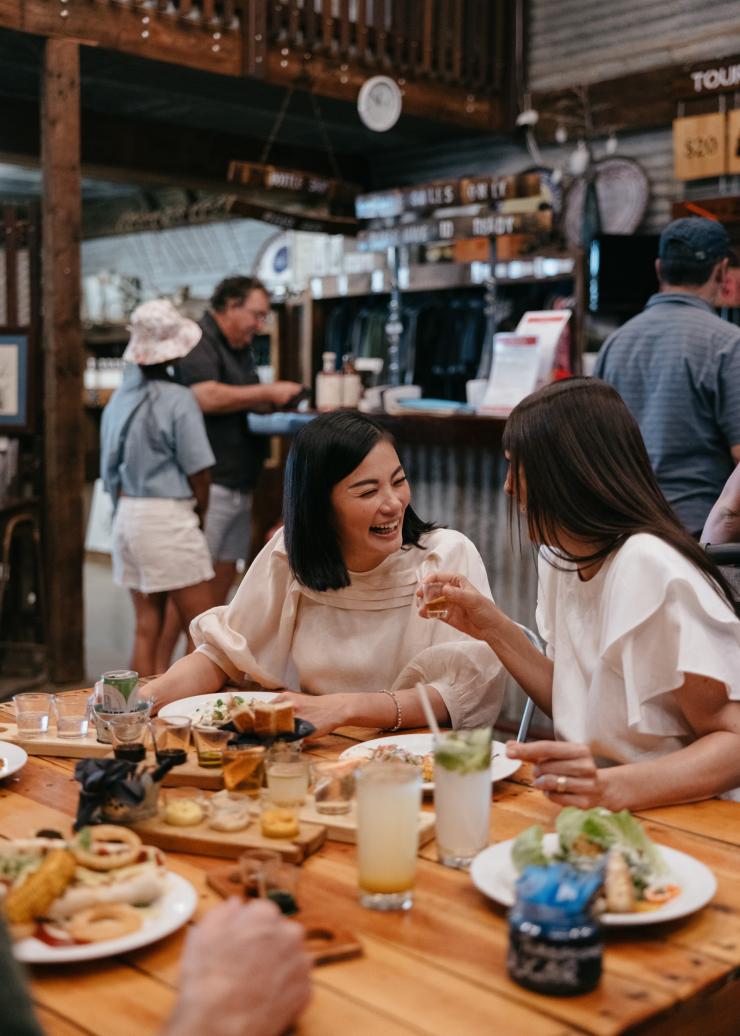 Friends enjoying lunch, cocktails and spirit tasting paddles at the Hoochery Distillery Café, Kununurra, Western Australia © Tourism Western Australia