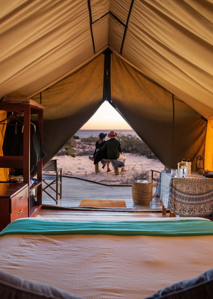 Interior of a Sal Salis luxury tent with a couple sitting outside admiring the ocean views at Ningaloo Reef, Western Australia © Sal Salis Ningaloo Reef 