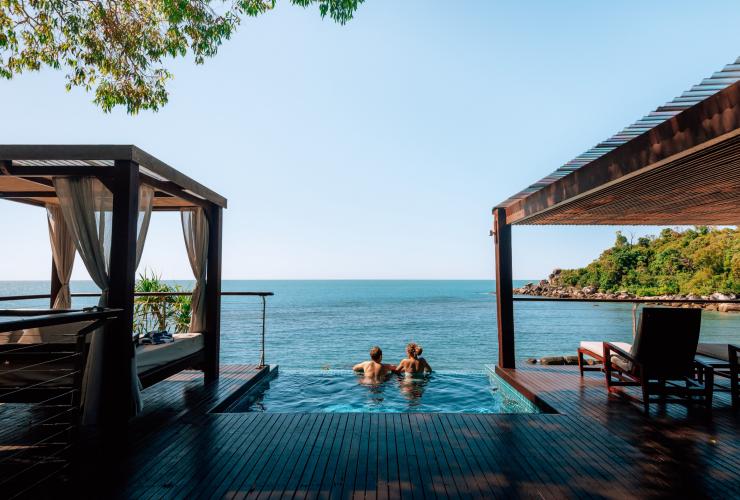 Two people swimming in an infinity pool overlooking the ocean on Bedarra Island, Queensland © Tourism and Events Queensland