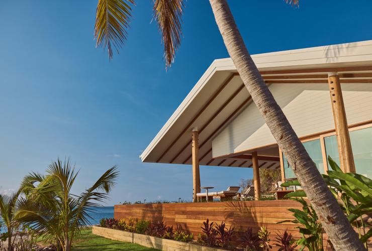Exterior of accommodation with a wide balcony and lounge chairs overlooking the ocean on Pelorus Private Island, Palm Island, Queensland © Jason Lerace/Pelorus Private Island