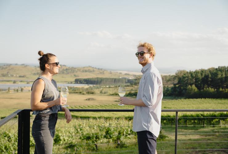 A couple share a glass of wine on the deck at Cubby and Co, Majura, ACT © Tourism Australia