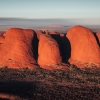 A large red rock monolith rising from the flat outback landscape at Uluru, Uluru-Kata Tjuta National Park, Northern Territory © Tourism Australia