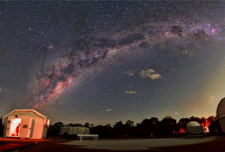 Domes lit up with red lights with people inside looking through telescopes at the starry night sky at Perth Observatory, Bickley, Western Australia © Perth Observatory/Andrew Lockwood