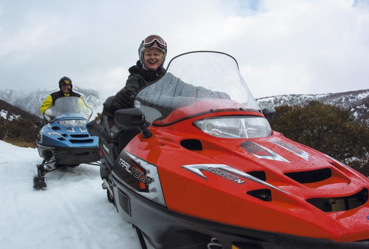 Two people riding snowmobiles on a snow covered mountain in Falls Creek, Victoria © Falls Creek Alpine Resort