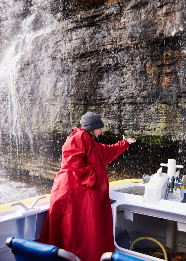 Woman taking a Pennicott Wilderness Journeys tour, Tasmania © Tourism Australia