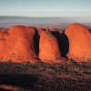 A large red rock monolith rising from the flat outback landscape at Uluru, Uluru-Kata Tjuta National Park, Northern Territory © Tourism Australia