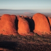 A large red rock monolith rising from the flat outback landscape at Uluru, Uluru-Kata Tjuta National Park, Northern Territory © Tourism Australia
