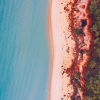 Aerial of a couple walking along a beach on a Salty Dog Adventure Tour in the Whitsundays, Queensland © Tourism and Events Queensland