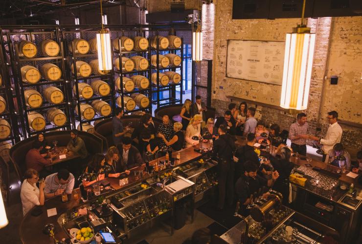 Vue de dessus d'un grand groupe réuni autour du comptoir d'un bar, sirotant des cocktails à Archie Rose, Sydney, Nouvelle-Galles du Sud © Archie Rose