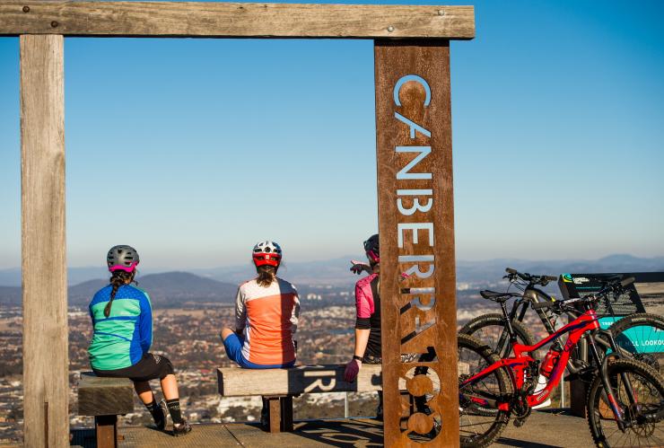 Gruppo di ciclisti che si riposano in un punto panoramico con vista sulla città lungo il Centenary Trail, Canberra, Australian Capital Territory © Damian Breach/VisitCanberra